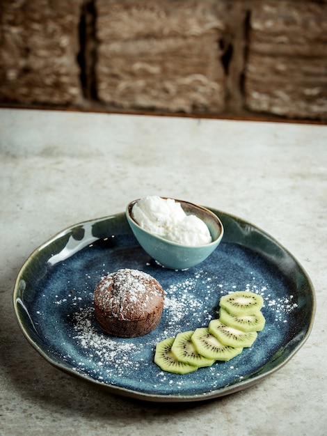 Schokoladenkuchen mit geschnittener Kiwi und Eiscreme