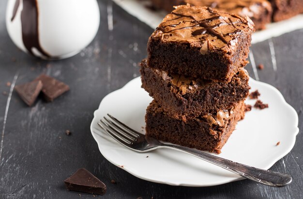 Schokoladenschokoladenkuchenkuchen-Stückstapel auf selbst gemachtem Gebäck der Platte