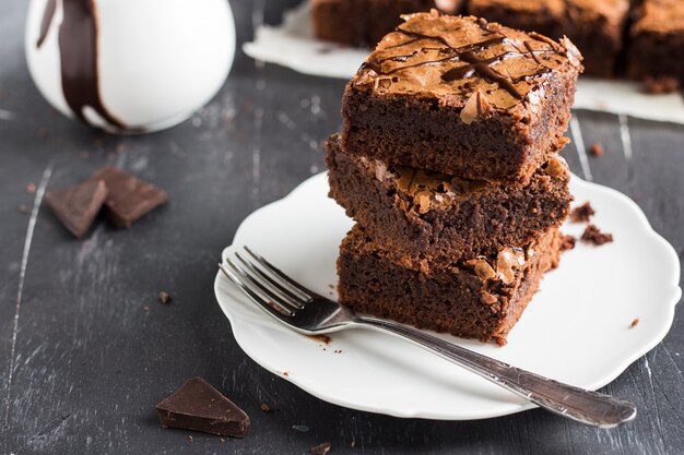 Schokoladenschokoladenkuchenkuchen-Stückstapel auf selbst gemachtem Gebäck der Platte
