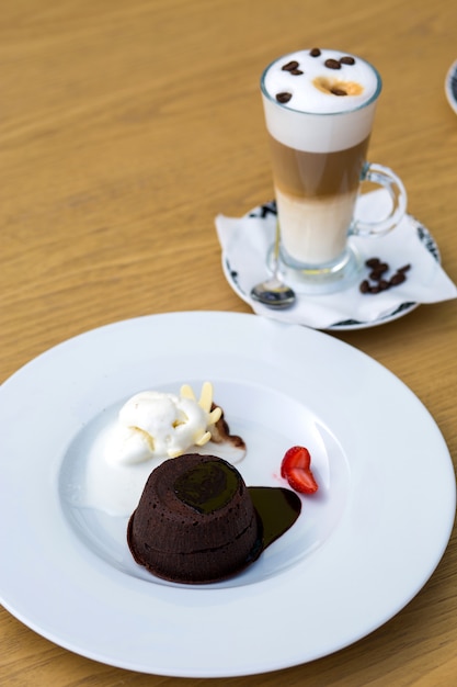 Kostenloses Foto schokoladenstückchen, serviert mit eiscreme und erdbeere und dreischichtigem latte