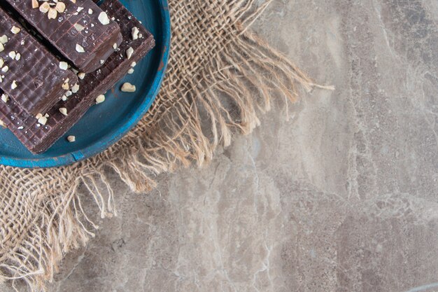 Schokoladenwaffel auf einer Holzplatte auf Textur auf Marmor.