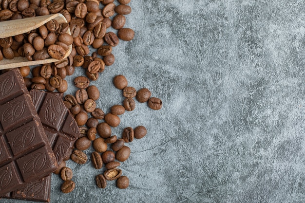 Schokoriegel mit Kaffeebohnen auf grau.