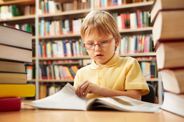 Schoolboy Drehen der Seite eines Buches