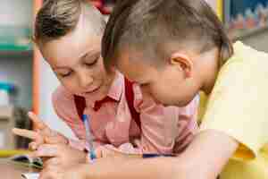 Kostenloses Foto schoolboys sitzen am schreibtisch