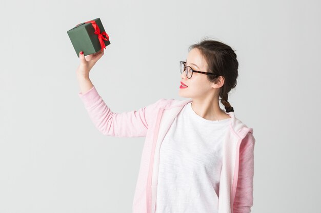 Schoss im Studio der jungen asiatischen Frau mit einem Weihnachtsgeschenk