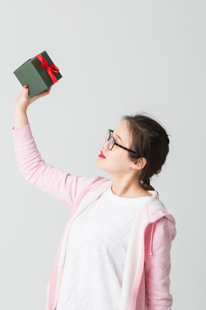 Schoss im Studio der jungen asiatischen Frau mit einem Weihnachtsgeschenk