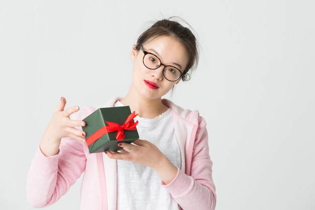 Schoss im Studio der jungen asiatischen Frau mit einem Weihnachtsgeschenk