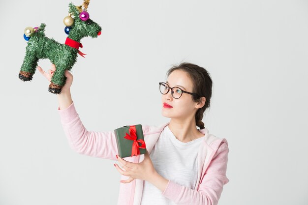 Schoss im Studio der jungen asiatischen Frau mit einem Weihnachtsgeschenk