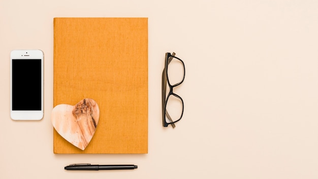 Kostenloses Foto schreibtisch mit buch, brille und stift