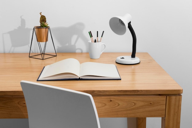 Schreibtischanordnung mit Buch und Lampe
