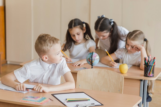 Schüler, der Mädchen hinter ihm betrachtet