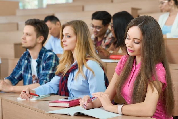 Schüler sitzen auf Holztischen im Klassenzimmer