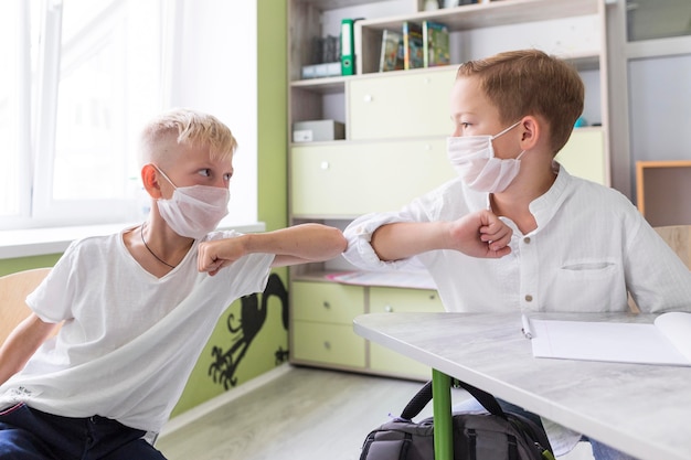 Schüler stoßen im Unterricht an den Ellbogen