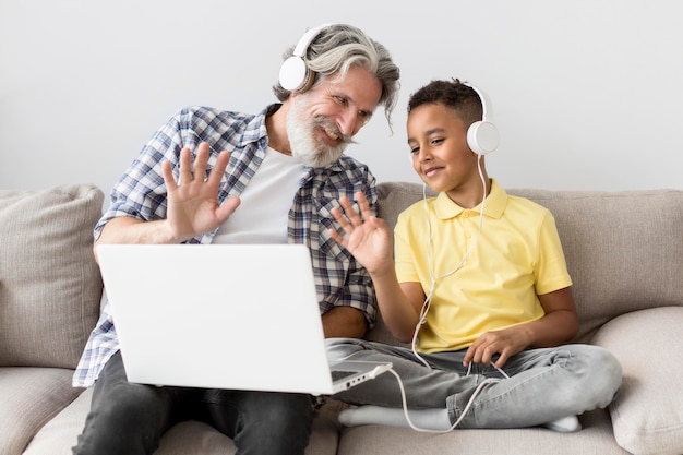 Schüler und Lehrer winken am Laptop