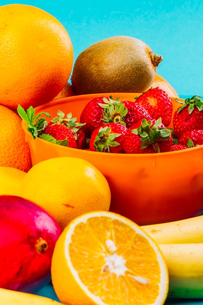 Schüssel Erdbeeren Orange; Kiwi und Banane auf blauem Hintergrund