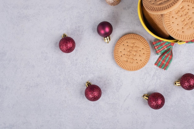 Schüssel kekse und weihnachtskugeln auf marmorhintergrund. hochwertiges foto