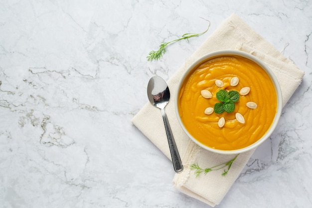 Schüssel Kürbissuppe auf weißem Stoff platzieren