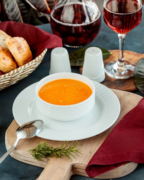 Schüssel linsensuppe serviert mit wein und brot