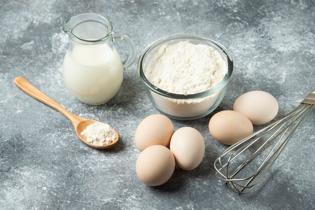 Schüssel mehl, eier und schnurrbart auf marmor.