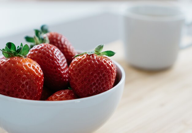 Schüssel mit Erdbeeren auf unscharfen Hintergrund