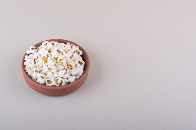 Schüssel mit gesalzenem Popcorn für Filmabend auf weißem Hintergrund. Foto in hoher Qualität