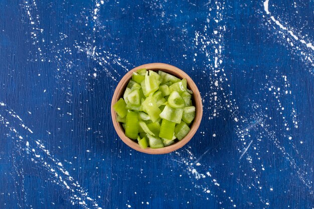 Schüssel mit geschnittenen grünen Paprika auf Marmoroberfläche