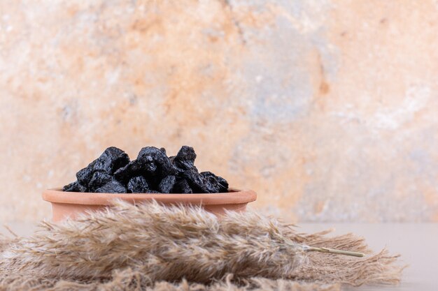 Schüssel mit getrockneten Pflaumenfrüchten auf weißem Hintergrund. Foto in hoher Qualität