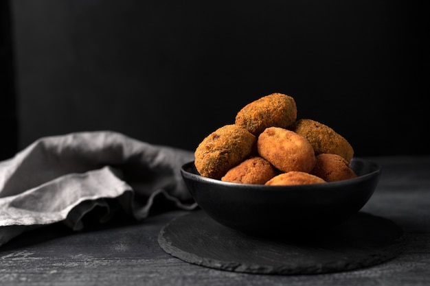 Schüssel mit Kroketten und Serviette im entschärften Hintergrund