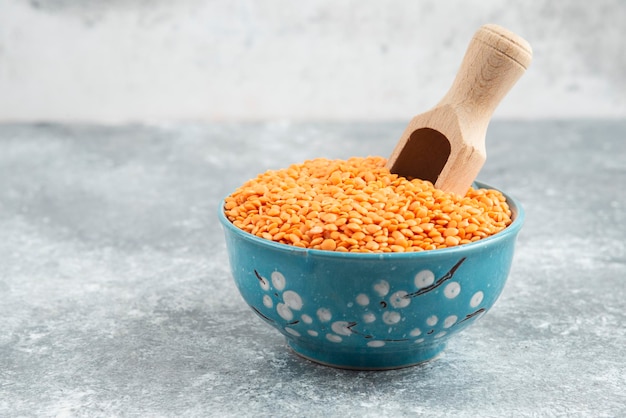 Kostenloses Foto schüssel mit rohen roten linsen auf marmortisch mit löffel.