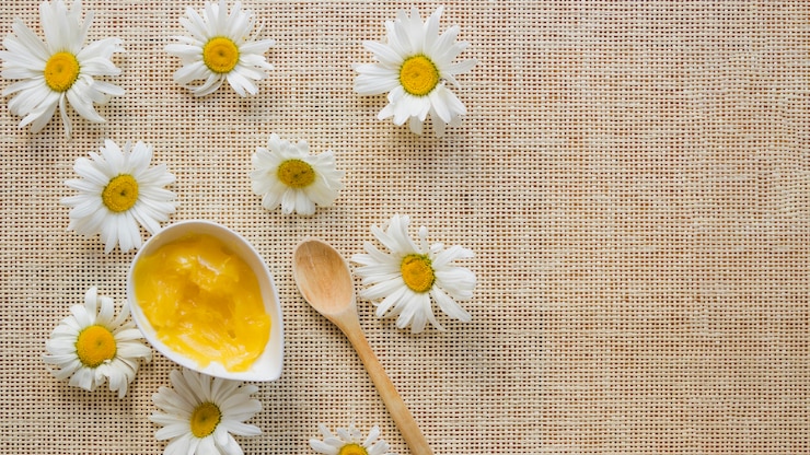 Kostenlose Foto schüssel mit sheabutter, löffel und kamillen