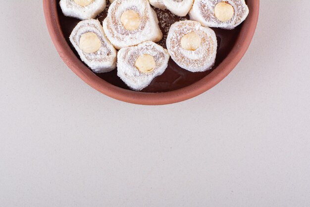 Schüssel mit süßem Lokum-Dessert mit Nüssen auf weißem Hintergrund. Foto in hoher Qualität