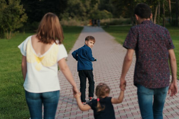 Schuljunge, der einen Roller im Park reitet