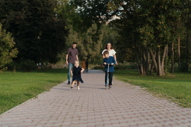 Schuljunge, der einen Roller im Park reitet