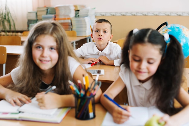 Schulkinder, die Spaß haben, im Klassenzimmer zu sitzen