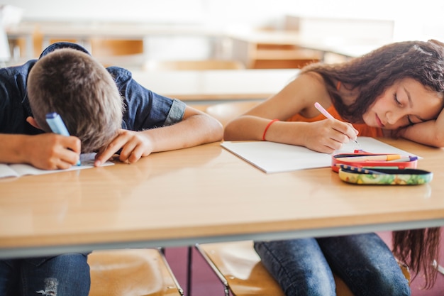 Kostenloses Foto schulkinder lehnen auf dem tisch schlafen