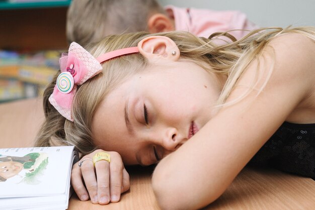 Schulkinder lehnen auf dem Tisch schlafen