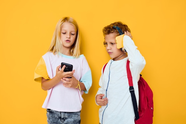 Schulkinder mit schulrucksäcken telefonunterhaltungskommunikation