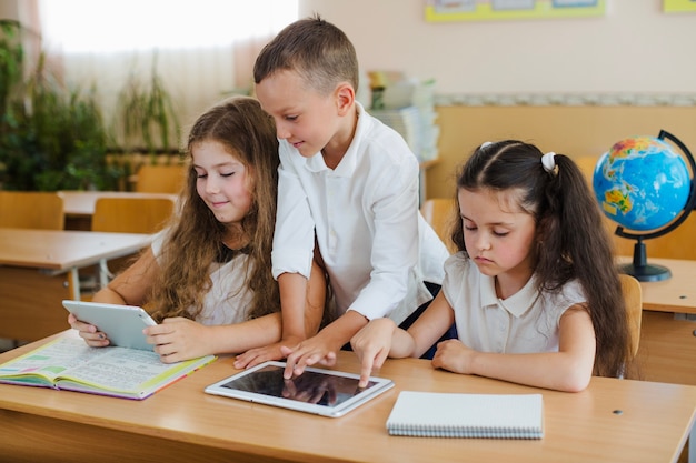 Schulkinder mit Tabletten im Klassenzimmer