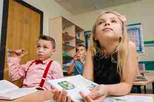 Kostenloses Foto schulkinder sitzen am unterricht zuhören