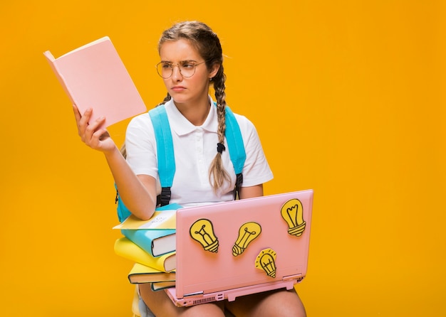 Schulmädchen auf Schreibtisch mit Laptop in der Memphis-Art