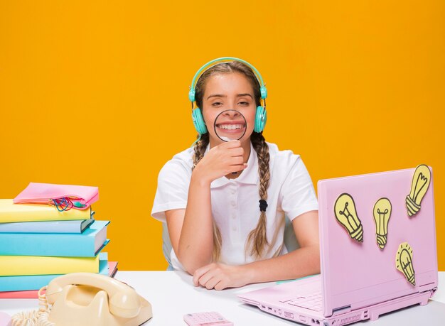 Schulmädchen auf Schreibtisch mit Laptop in der Memphis-Art