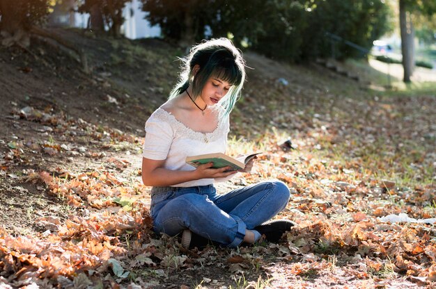 Schulmädchen lesen auf sonnigen Hügel