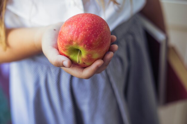 Schulmädchen mit Apfel in der Hand
