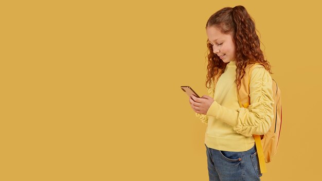 Schulmädchen mit gelbem Hemd, das den Telefonkopierraum betrachtet