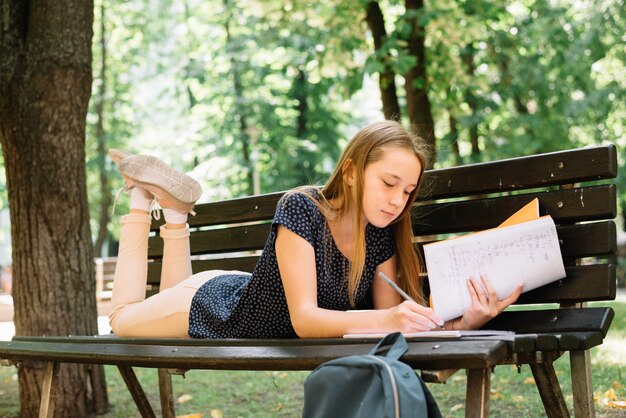 Schulmädchen studieren auf Bank mit Büchern