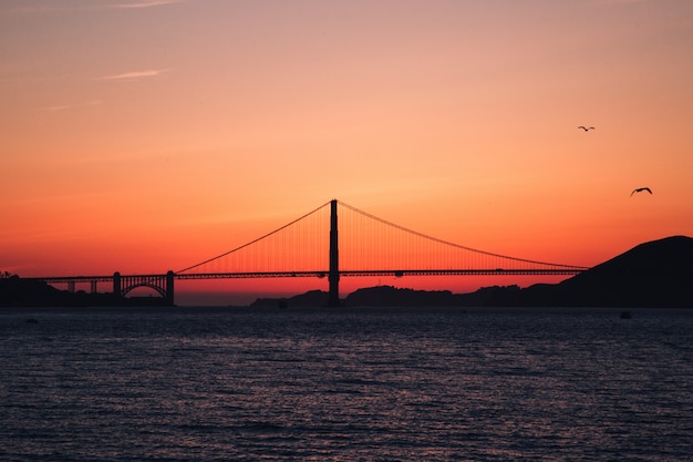 Schuss der Golden Gate Bridge auf dem Gewässer während des Sonnenuntergangs in San Francisco, Kalifornien