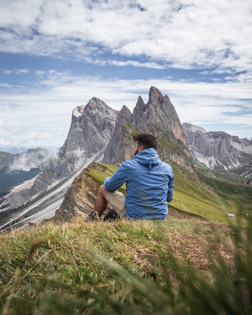 Schuss eines Mannes, der das Tal und die Berge des Naturparks Puez-Geisler, Italien betrachtet