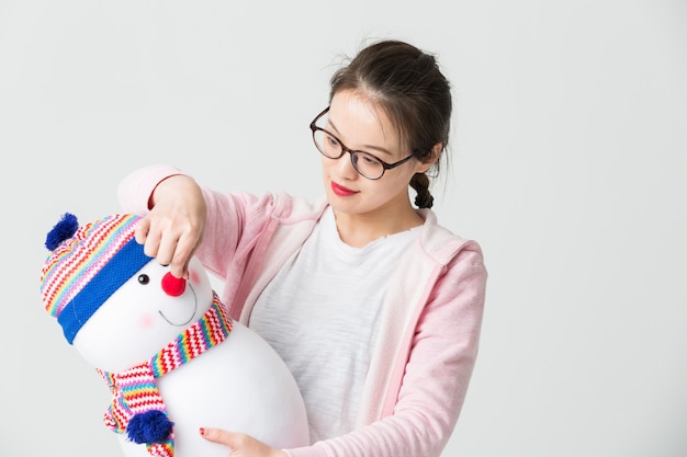 Schuss im Studio der jungen asiatischen Frau mit einem Weihnachts-Schneemann