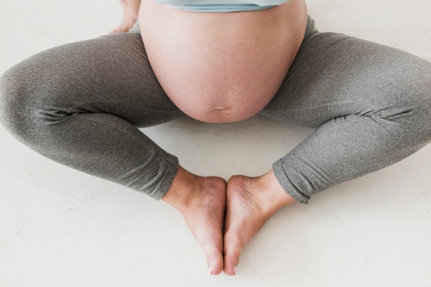 Schwangere Frau der Draufsicht, die Yoga tut
