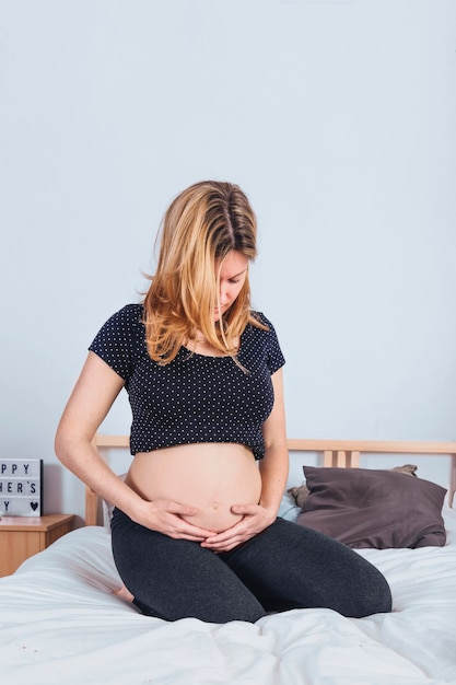 Schwangere Frau, die Bauch hält